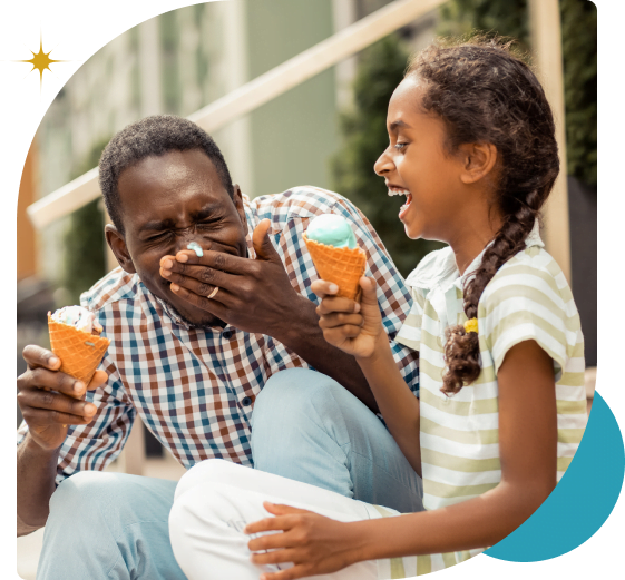 Happy dad and daughter eating ice cream outside and laughing
