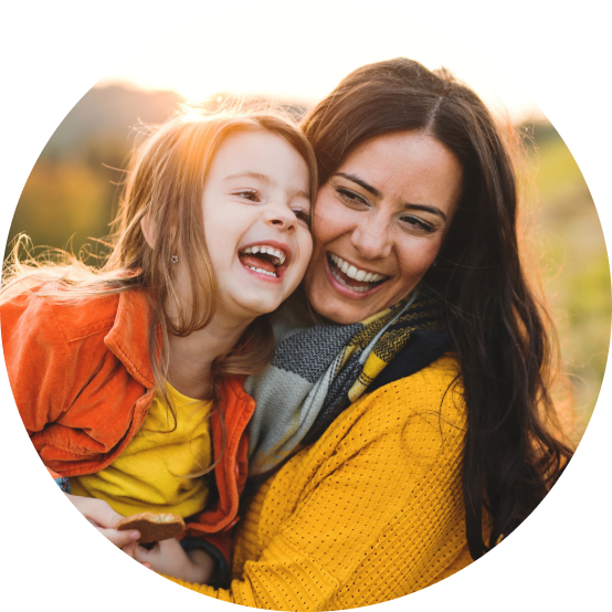 Happy mom and child outside in Utah laughing and smiling with the sun shining
